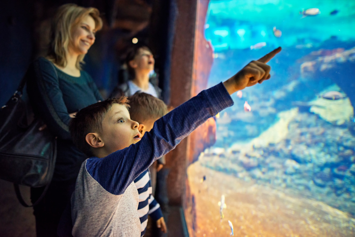 Mother with kids visiting a huge aquarium