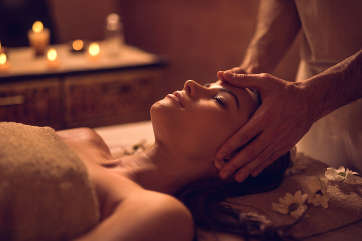 Young woman enjoying during head massage at the spa.